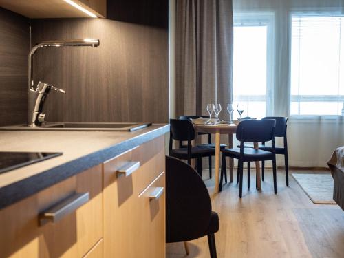 a kitchen with a table and chairs in a room at Nallikari Holiday Village - Aalto Seaside Apartments in Oulu