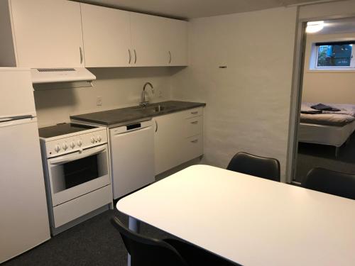 a kitchen with white cabinets and a table with a sink at Jysk bed and no breakfast in Ikast