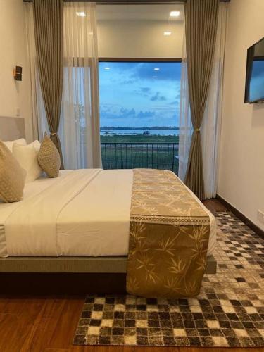 a bedroom with a large bed with a large window at Blue Wild - Yala - Plastic Free & Sustainable in Tissamaharama