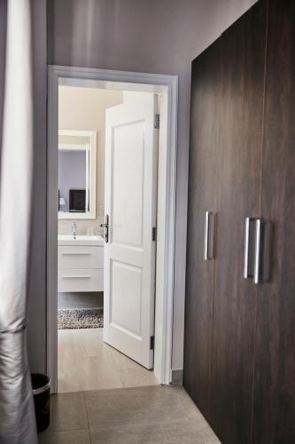 a bathroom with a white door and a sink at Palacina The Residence & The Suites in Nairobi