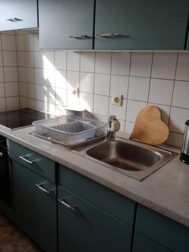 a kitchen counter with a sink and a cutting board at Ferienwohnung am Garten in Weißenberg
