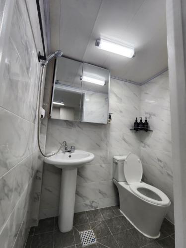 een badkamer met een wastafel, een toilet en een spiegel bij LaonHajae in Seoul