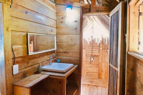 baño con lavabo y pared de madera en Private Beachfront House with Kayak & Guided Tours, en Changuinola