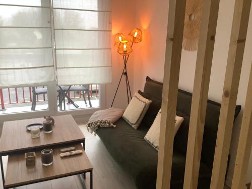 un salon avec un canapé et une table dans l'établissement Scidesdunes, à Merville-Franceville-Plage