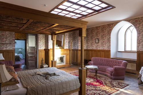 Laitse castle في Laitse: غرفة معيشة مع سرير كبير وأريكة