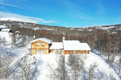 a wooden house is covered in snow at Sunny and beautiful cabin in Geilo in Geilo