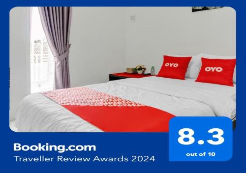 a bedroom with a bed with two red pillows at Super OYO 90730 Padekosan in Tulungagung