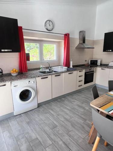 a kitchen with a sink and a washing machine at Typical quiet Algarve cottage in Faro