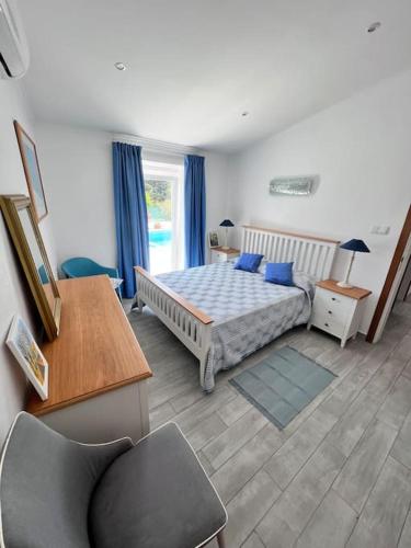 a bedroom with a bed and a desk and a chair at Typical quiet Algarve cottage in Faro