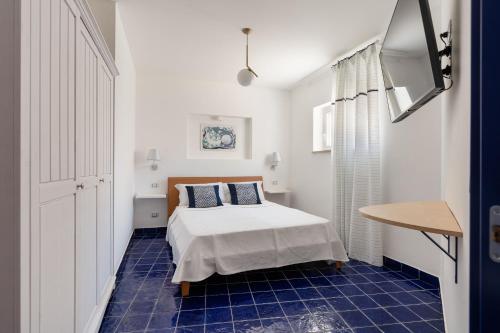 a bedroom with a bed and a blue tile floor at Don Leonardo - pool and wellness in Polignano a Mare