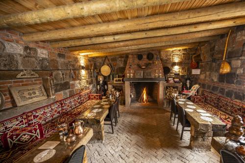 een restaurant met tafels en stoelen en een open haard bij Doğunun Taş Evleri in Selim