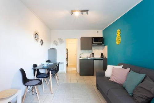 un salon avec un canapé et une cuisine dans l'établissement Chez Alexandra - Élégant studio avec parking à proximité des plages, à La Grande Motte