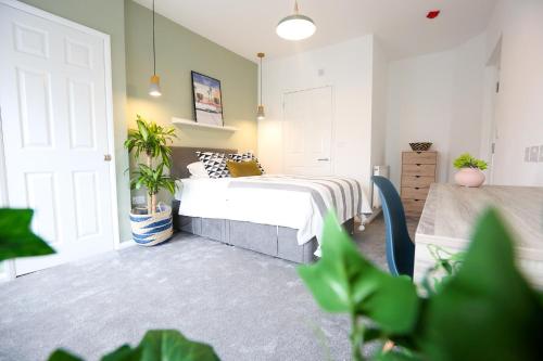 Un dormitorio con una cama y plantas. en Contractors Dream 7 bed 7 ensuite en Birkenhead