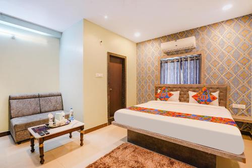 a bedroom with a large bed and a table at FabHotel Lio7 Grand in Hyderabad