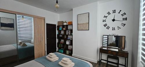 a bedroom with a clock on the wall and a bed at The Cave by the Tower Bridge spacious KING BEDROOM in London