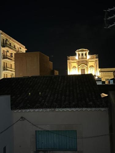a building with a clock tower in the background at night at Cavour69 in Avola