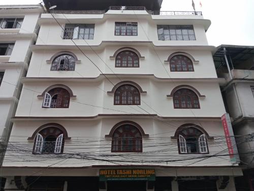 a tall white building with many windows at HOTEL TASHI NORLING Near Mall Road in Gangtok