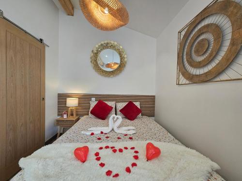 a bedroom with a bed with red hearts on it at Gîte Luxe DOUCE HARMONIE SPA & MASSAGES Offre Spéciale in Villemoustaussou