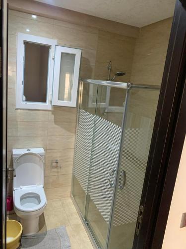 a bathroom with a toilet and a glass shower at Résidence Amwej in Port El Kantaoui
