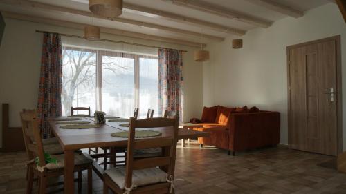 een woonkamer met een tafel en stoelen en een bank bij Domek w Lasówce in Lasowka