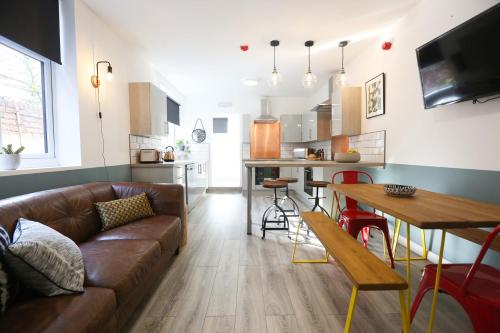 sala de estar con sofá marrón y cocina en Contractors Dream 7 bed 7 ensuite en Birkenhead