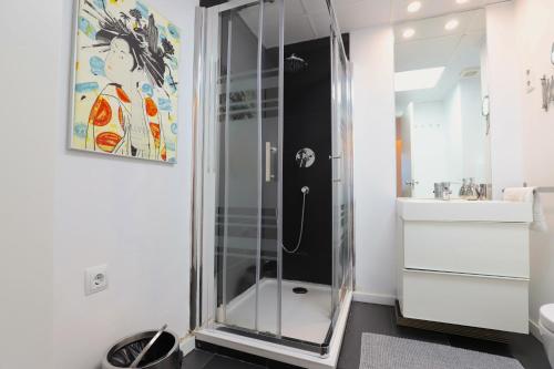 Apartamento Superior Centro Madrid في مدريد: دش زجاجي في حمام مع حوض