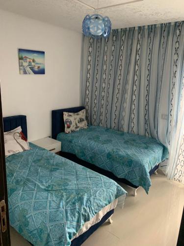 a bedroom with a twin bed and a window at Résidence Amwej in Port El Kantaoui