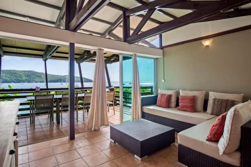 a living room with a couch and a balcony at Villa Fleur D'eau in Grande Anse