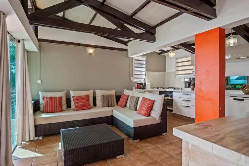 a living room with a couch and a kitchen at Villa Fleur D'eau in Grande Anse