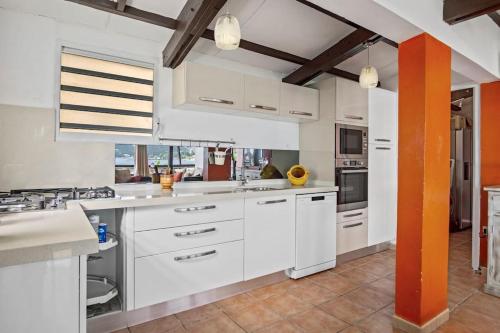 a large kitchen with white cabinets and appliances at Villa Fleur D'eau in Grande Anse
