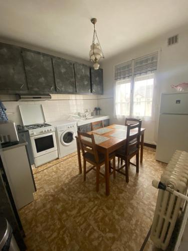 eine Küche mit einem Holztisch, Stühlen und einem Herd in der Unterkunft appartement de 50m2 grand et spacieux avec jardin in Viry-Châtillon