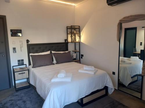 sypialnia z dużym białym łóżkiem z ręcznikami w obiekcie Studio Mayer w mieście Patras