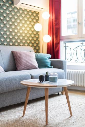 un salon avec un canapé et une table basse dans l'établissement Appartement d'architecte proche Arc de Triomphe-2P, à Paris