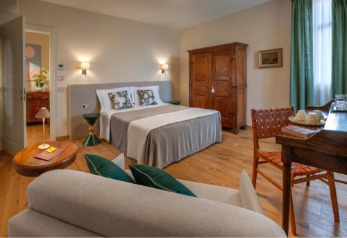 モンフォルテ・ダルバにあるAgriturismo Ca' Brusàのベッドとリビングルームが備わるホテルルームです。