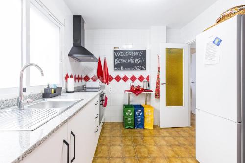 a white kitchen with a sink and a refrigerator at The Beach -Villa Mar- in Bolnuevo