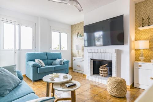 a living room with a blue couch and a fireplace at The Beach -Villa Mar- in Bolnuevo