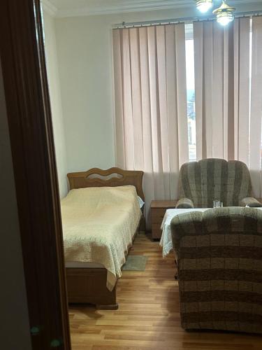 sypialnia z łóżkiem, krzesłem i oknem w obiekcie Levon 2 Hotel, Restoran w mieście Noyemberyan