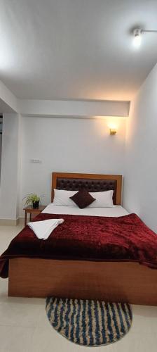 sypialnia z dużym łóżkiem i czerwonym kocem w obiekcie Shanti homestay w mieście Temi