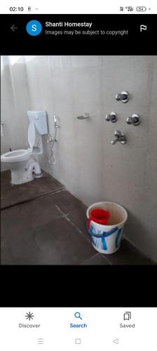 a picture of a bathroom with a toilet and a bucket at Shanti homestay in Temi