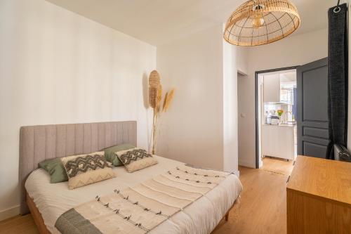 une chambre avec un grand lit avec des oreillers dessus dans l'établissement Charmant appartement haut de gamme, à Bordeaux