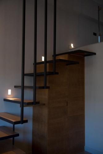 a wooden staircase with black railings in a room at ILION Air Host - near Athens International Airport in Markopoulo