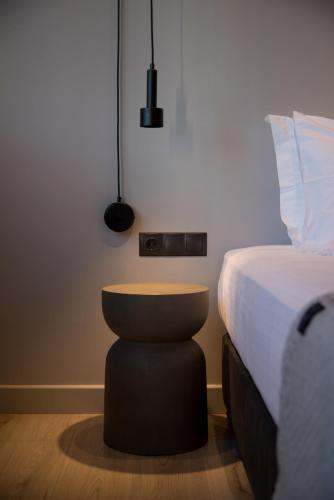 a bedroom with a bed and a stool next to it at ILION Air Host - near Athens International Airport in Markopoulo