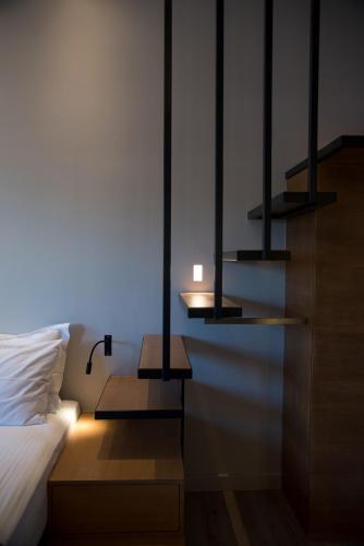 a bedroom with a bed and two lights on the wall at ILION Air Host - near Athens International Airport in Markopoulo