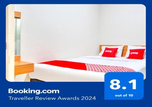 een hotelkamer met een bed met rode kussens bij OYO 3346 Rukos Colombus G5 in Telukjambe