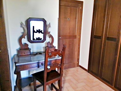 a dressing table with a mirror and a chair in a room at La Collina dei Venti in Gualdo Cattaneo