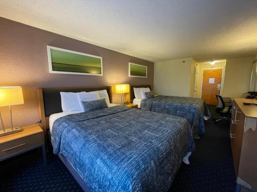 a hotel room with two beds and a desk at Lakeside Inn in Wakefield