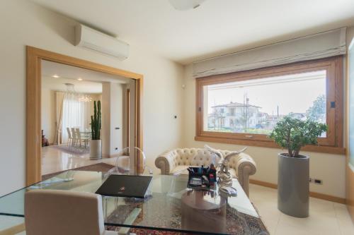 sala de estar con mesa de cristal y ordenador portátil. en Villa Vescovado casa vacanza en Brusaporto