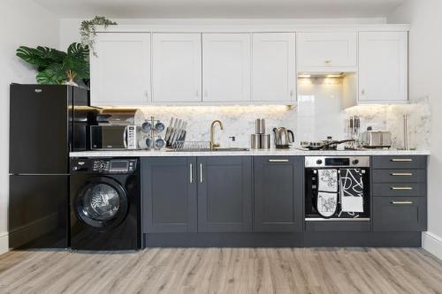 a kitchen with a sink and a washing machine at WhiskAwayStays - Victoria House - Apartment 4 in Worcester