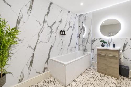 a bathroom with a white tub and a marble wall at WhiskAwayStays - Victoria House - Apartment 4 in Worcester