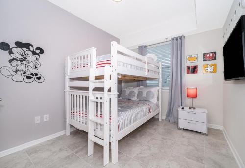 ein weißes Etagenbett in einem weißen Zimmer in der Unterkunft 3180-202BV STOREY LAKE, CONDO 2/2 GARDEN VIEW in Kissimmee